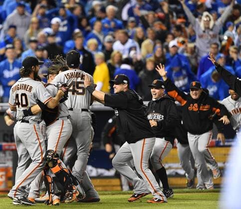 San Francisco Giants catcher Buster Posey hugs MVP Madison Bumgarner (L) as the Giants rush the field after final out against the Kansas City Royals in game 7 of the World Series at Kauffman Stadium in Kansas City, Missouri on October 29, 2014. San Francisco wins the World Series defeating Kansas City 3-2.  KCP2014102980