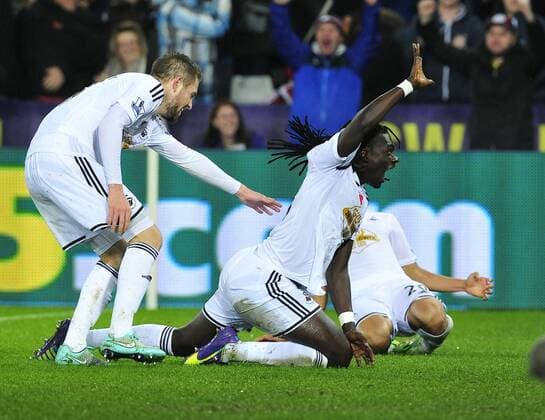 Football - 2014 2015 Premier League - Swansea City vs. Arsenal Bafétimbi Gomis of Swansea scores their 2nd goal at The Liberty Stadium. COLORSPORT WINSTON BYNORTH 