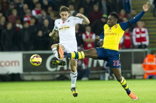 Football - 2014 2015 Premier League - Swansea City vs. Arsenal ÃÄngel Rangel of Swansea & Danny Welbeck at The Liberty Stadium. COLORSPORT WINSTON BYNORTH 
