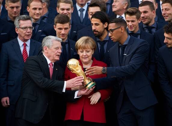 Jerome BOATENG überreicht Bundespräsident Joachim GAUCK den Weltmeisterpokal, Mitte: Bundeskanzlerin Angela MERKEL Gruppenfoto vor dem Schloss Bellevue Sportlerauszeichnung - Verleihung des Silbernen Lorbeerblattes durch den Bundespräsidenten für die deutsche Fussballnationalmannschaft im Schloss Bellevue in Berlin, Deutschland am 10.11.2014.