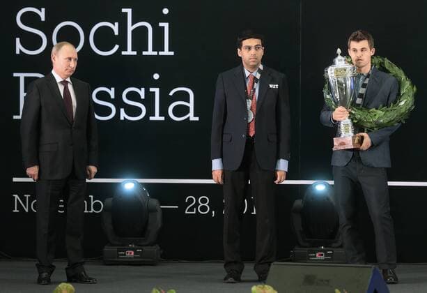 SOCHI, RUSSIA.NOVEMBER 25, 2014. Russia s president Vladimir Putin, Indian chess player Viswanathan (Vishy) Anand look on as chess champion Magnus Carlsen (L-R) of Norway receives his trophy after winning the FIDE World Chess Championship 2014.  premiumd S0082F0C