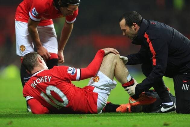 Wayne Rooney of Manchester United holds his knee after falling into the advertising boards - Manchester United (ManU) vs. Hull City - Barclay s Premier League - Old Trafford - Manchester - 29 11 2014 - EDITORIAL USE ONLY. No use with unauthorised audio, video, data, fixture lists, club league logos or live services. Online in-match use limited to 120 images, no video emulation. No use in betting, games or single club league player publications.