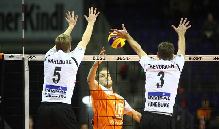 Berlin, Deutschland, 29.11.2014: Volleyball Bundesliga 2014 2015 - BR Volleys - SVG Lueneburg. Christian Dünnes Duennes (BR Volleys 16) gegen den Block aus Rene Bahlburg (Lueneburg) und Scott Kevorken (Lueneburg)