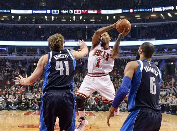 Chicago Bulls guard Derrick Rose (C) goes up for a shot as Dallas Mavericks forward Dirk Nowitzki (L) and center Tyson Chandler defend during the first quarter at the United Center on December 2, 2014 in Chicago.  CHI2014120212