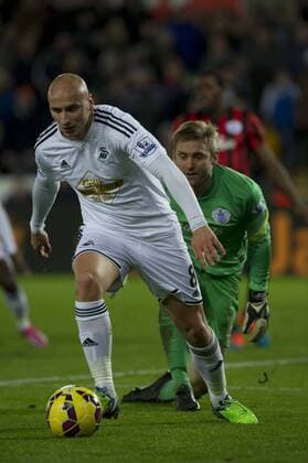 Football - 2014 2015 Premier League - Swansea City vs. Queens Park Rangers Jonjo Shelvey of Swansea tries to beat Robert Green of QPR at The Liberty Stadium. COLORSPORT WINSTON BYNORTH 