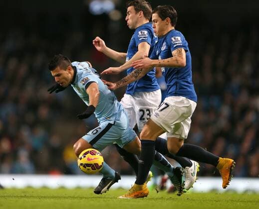 Sergio Kun Aguero of Manchester City tussles with Seamus Coleman and Muhamed Besic of Everton which leads to him going off injured - Barclays Premier League - Manchester City vs Everton FC - Etihad Stadium - Manchester - England - 6th December 2014 - EDITORIAL USE ONLY. No use with unauthorised audio, video, data, fixture lists, club league logos or live services. Online in-match use limited to 120 images, no video emulation. No use in betting, games or single club league player publications.