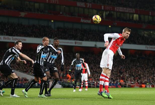 Arsenal s Per Mertesacker s header hits the bar Barclays Premier League- Arsenal FC vs Newcastle United - Emirates Stadium - England - 13th December 2014 - EDITORIAL USE ONLY. No use with unauthorised audio, video, data, fixture lists, club league logos or live services. Online in-match use limited to 120 images, no video emulation. No use in betting, games or single club league player publications.