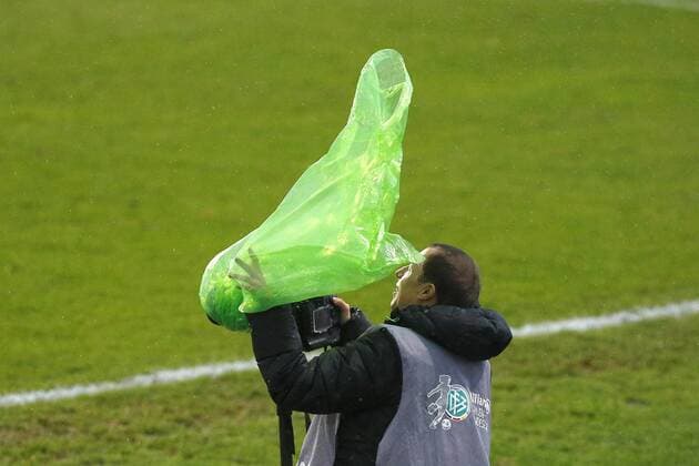 20.12.2014, VfL Stadion am Elsterweg, Wolfsburg, GER, DFB Pokal, Frauen, Viertelfinale, VfL Wolfsburg vs SC Sand, im Bild Dem Fotografen fliegt im Sturm sein Regenschutz davon VfL Wolfsburg vs SC Sand