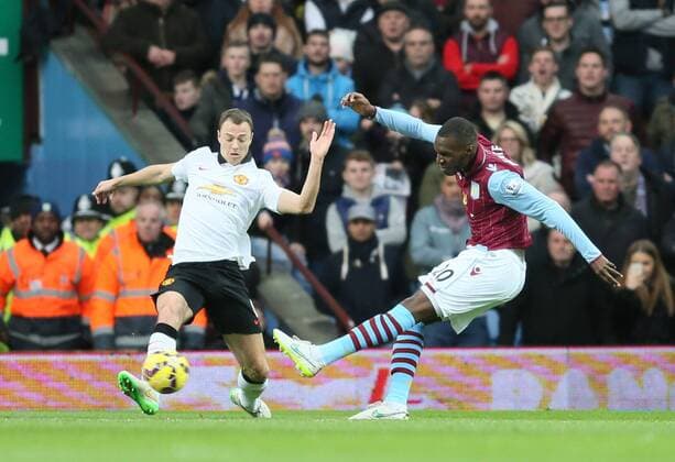 Christian Benteke of Aston Villa shoots past Jonny Evans of Manchester United ManU to score the first goal - Barclays Premier League - Aston Villa vs Manchester United Villa Park Stadium - Birmingham - England - 20th December 2014 - Picture SimonBellis Sportimage EDITORIAL USE ONLY. No use with unauthorised audio, video, data, fixture lists, club league logos or live services. Online in-match use limited to 120 images, no video emulation. No use in betting, games or single club league player publications.