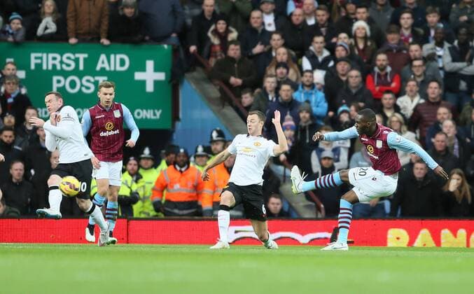 Christian Benteke of Aston Villa shoots past Jonny Evans of Manchester United ManU to score the first goal - Barclays Premier League - Aston Villa vs Manchester United Villa Park Stadium - Birmingham - England - 20th December 2014 - Picture SimonBellis Sportimage EDITORIAL USE ONLY. No use with unauthorised audio, video, data, fixture lists, club league logos or live services. Online in-match use limited to 120 images, no video emulation. No use in betting, games or single club league player publications.