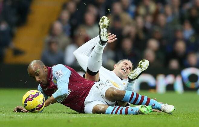 Robin van Persie of Manchester United ManU tackled hard by Fabian Delph of Aston Villa - Barclays Premier League - Aston Villa vs Manchester United Villa Park Stadium - Birmingham - England - 20th December 2014 - Picture SimonBellis Sportimage EDITORIAL USE ONLY. No use with unauthorised audio, video, data, fixture lists, club league logos or live services. Online in-match use limited to 120 images, no video emulation. No use in betting, games or single club league player publications.