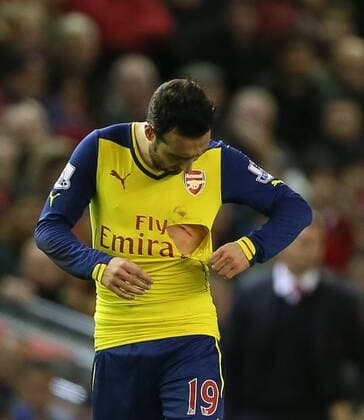 Aktuell Fußball, England, Premier League, Santi Carzola vom FC Arsenal mit kurioser Verletzung Arsenal s Santi Cazorla looks at his cut and ripped shirt after a high tackle Barclays Premier League - Liverpool FC vs Arsenal FC - Anfield - England - 21st December 2014 - EDITORIAL USE ONLY. No use with unauthorised audio, video, data, fixture lists, club league logos or live services. Online in-match use limited to 120 images, no video emulation. No use in betting, games or single club league player publications.