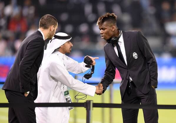 FUSSBALL INTERNATIONAL Supercoppa Italia Finale 2014 in Doha Juventus Turin - SSC Neapel 22.12.2014 Paul Pogba (re, Juventus Turin) wird von einem Offiziellen begruesst 