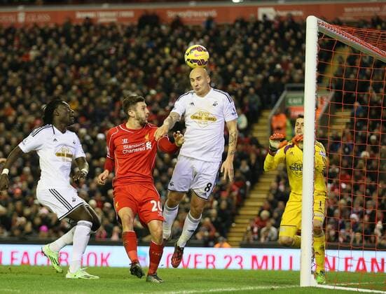 Jonjo Shelvey of Swansea City gets a touch to score an own goal - Barclays Premier League - FC Liverpool vs Swansea City - Anfield Stadium - Liverpool - England - 29th December 2014 - EDITORIAL USE ONLY. No use with unauthorised audio, video, data, fixture lists, club league logos or live services. Online in-match use limited to 120 images, no video emulation. No use in betting, games or single club league player publications.