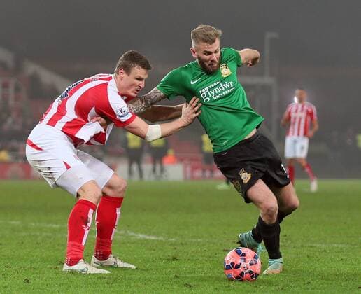 Robert Huth of Stoke City holds up Andy Bishop of Wrexham - FA Cup Third Round - Stoke City vs Wrexham - Britannia Stadium - Stoke on Trent - England - 4th January 2015 - Picture Simon Bellis Sportimage EDITORIAL USE ONLY. No use with unauthorised audio, video, data, fixture lists, club league logos or live services. Online in-match use limited to 120 images, no video emulation. No use in betting, games or single club league player publications.