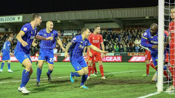 Aktuell Fußball, England, FA Cup, AFC Wimbledon - FC Liverpool Football - 2014 2015 FA Cup - Third Round: AFC Wimbledon - FC Liverpool, AFC Wimbledon s Adebayo Akinfenwa turns away in celebration after scoring the equalising goal at The Cherry Red Records Stadium  WIM_LIV