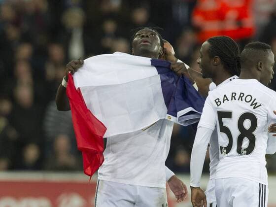 Aktuell Fußball, England, Premier League, Swansea City - West Ham United Football - 2014 2015 Premier League - Swansea City vs. West Ham United Bafétimbi Gomis of Swansea celebrates scoring with a tricoleur, french flag, at The Liberty Stadium. COLORSPORT WINSTON BYNORTH 