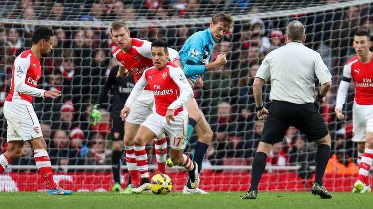 Football - 2014 2015 - Barclays Premier League, - Arsenal Vs Stoke City, Arsenal s Alexis Sanchez nips in front of Stoke City s Peter Crouch and Arsenal s Per Mertesacker to steal the ball at The Emirates Stadium ARS_STO