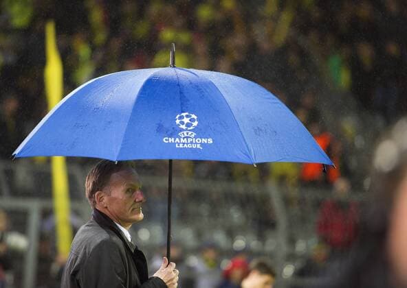 Mittwoch 21.08.2013, UEFA Champions League, 6. Spieltag, Saison 2013 2014 in Dortmund, BVB Borussia Dortmund - FC Arsenal London, Vorsitzender Geschaeftsfuehrer Hans-Joachim Watzke (BVB) hält einen Regenschirm. DeFodi01040001220