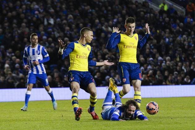 25.01.2015. Brighton, England. FA Cup 4th Round. Brighton and Hove Albion vs Arsenal FC. Brighton and Hove Albion s Inigo Calderon goes down after a challenge by Arsenal s Laurent Koscielny (right) and appeals for a penalty xCraigxMercerx  ActionPlus11592546