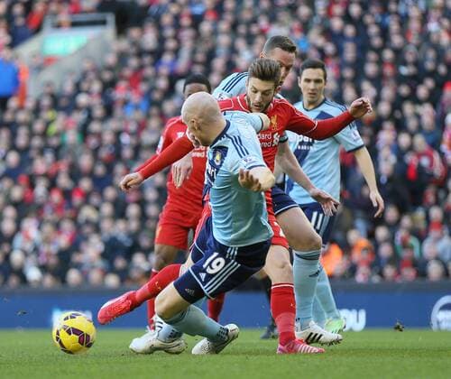 James Collins of West Ham United intercepts Adam Lallana of FC Liverpool - Barclays Premier League - FC Liverpool vs West Ham United - Anfield Stadium - Liverpool - England - 31st January 2015 - EDITORIAL USE ONLY. No use with unauthorised audio, video, data, fixture lists, club league logos or live services. Online in-match use limited to 120 images, no video emulation. No use in betting, games or single club league player publications.