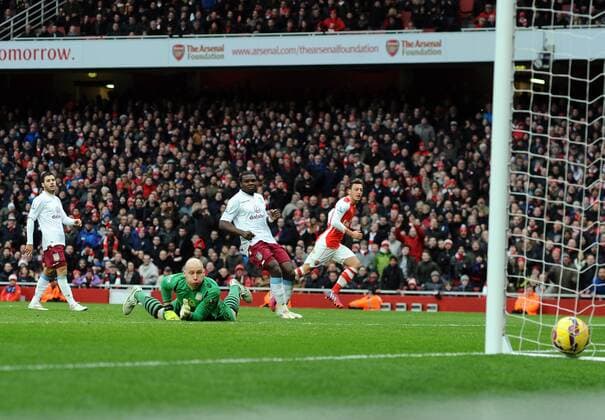 Aktuell Fußball, England, Premier League, FC Arsenal - Aston Villa Football - 2014 2015 Premier League - Arsenal vs. Aston Villa Arsenal s Mesut Ozil scores goal no 2 past the diving Bradley Guzan at The Emirates. COLORSPORT ANDREW COWIE 