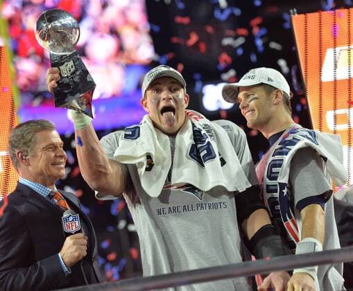 New England Patriots TE Rob Gronkowski (C) folds up the Vince Lombardi Trophy with Tom Brady (R) after defeating the Seattle Seahawks 28-24 to win Super Bowl XLIX at University of Phoenix Stadium in Glendale, Arizona, February 1, 2015.  SBP20150201105 KEVINxDIETSCH