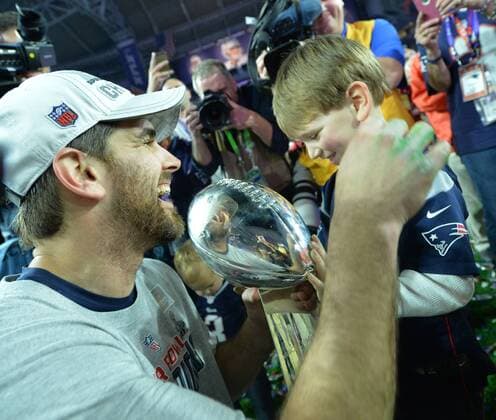 New England Patriots kicker Stephen Gostkowski and son Slayden, celebrate with the Vince Lombardi Trophy after the Patriots defeated the Seattle Seahawks 28-24 to win Super Bowl XLIX at University of Phoenix Stadium in Glendale, Arizona, February 1, 2015.  SBP20150201124 KEVINxDIETSCH
