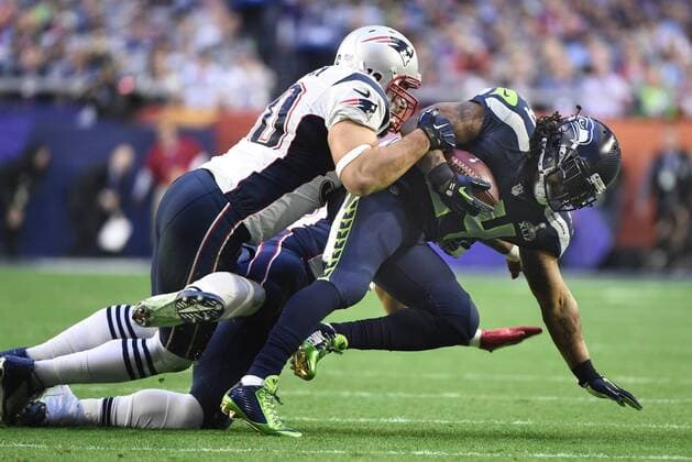 Seattle Seahawks quarterback Marshawn Lynch (R) is tackled after a five yard gain against the New England Patriots in the first quarter of Super Bowl XLIX at University of Phoenix Stadium in Glendale, Arizona, February 1, 2015.  SBP20150201048 KEVINxDIETSCH