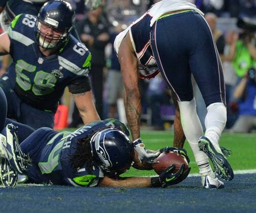 Seattle Seahawks Marshawn Lynch (24) pushes the ball over the goal line for a three yard TD against the New England Patriots in the second quarter of Super Bowl XLIX at University of Phoenix Stadium in Glendale, Arizona, February 1, 2015.  SBP20150201056 KEVINxDIETSCH