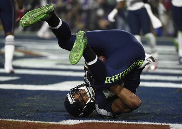 Seattle Seahawks Doug Baldwin rolls with a three yard TD pass from Russell Wilson in the third quarter against the New England Patriots at Super Bowl XLIX at University of Phoenix Stadium in Glendale, Arizona, February 1, 2015.  SBP20150201080 KEVINxDIETSCH