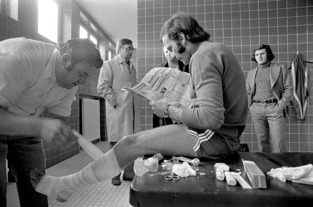 FUSSBALL 1. BUNDESLIGA SAISON 1972 1973 FC Bayern Muenchen Franz ROTH (Mitte) liest Zeitung und wird von Dr. Mueller am Fuss behandelt 01.10.1972 xxNOxMODELxRELEASExx