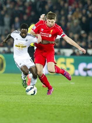 Football - 2014 2015 Premier League - Swansea City vs. LIVERPOOL Liverpool Midfielder Steven Gerrard tackles Nathan Dyer of Swansea at the Liberty Stadium. Â© winston bynorth COLORSPORT WINSTON BYNORTH 
