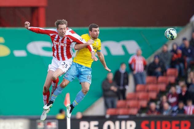 21.03.2015. Stoke, England. Barclays Premier League. Stoke City versus Crystal Palace. Stoke City forward Peter Crouch and Crystal Palace midfielder James McArthur jump for the ball. xTimxWilliamsx  ActionPlus11606966