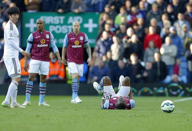 Christian Benteke of Aston Villa struggles with an injury in the second half - Football - Barclays Premier League - Aston Villa vs Swansea City - Villa Park Birmingham - Season 2014 15 - 21st March 2015 - Photo Malcolm Couzens Sportimage EDITORIAL USE ONLY. No use with unauthorised audio, video, data, fixture lists, club league logos or live services. Online in-match use limited to 120 images, no video emulation. No use in betting, games or single club league player publications.
