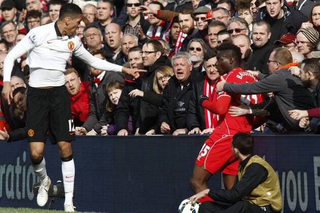 22.03.2015. Liverpool, England. Barclays Premier League. FC Liverpool versus Manchester United ManU - Manchester United defender Chris Smalling points the finger at Liverpool striker Mario Balotelli as Balotelli is held back by Liverpool fans. xAlanxMartinx  ActionPlus11607396