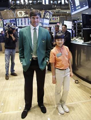 Defending Masters Champion Bubba Watson and 10-Year-Old Drive, Chip & Putt Champion Kelly Xu stand on the floor of the NYSE before the closing bell at the New York Stock Exchange on Wall Street in New York City on March 24, 2015. Their appearance at the NYSE is to celebrate Bubba s defense of his 2014 Masters title just two weeks later and Kelly s defense of her Drive, Chip and Putt title at Augusta National the Sunday before the Masters Tournament.  NYP20150324107 JOHNxANGELILLO