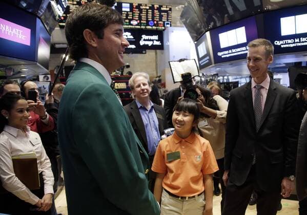 Defending Masters Champion Bubba Watson and 10-Year-Old Drive, Chip & Putt Champion Kelly Xu stand on the floor of the NYSE before the closing bell at the New York Stock Exchange on Wall Street in New York City on March 24, 2015. Their appearance at the NYSE is to celebrate Bubba s defense of his 2014 Masters title just two weeks later and Kelly s defense of her Drive, Chip and Putt title at Augusta National the Sunday before the Masters Tournament.  NYP20150324111 JOHNxANGELILLO
