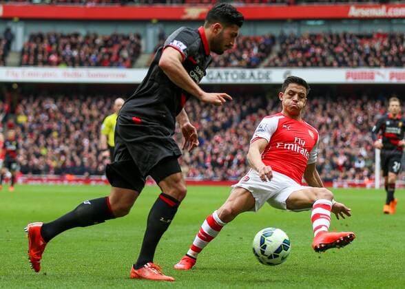 Football - 2014 2015 - Barclays Premier League, - Arsenal Vs Liverpool, Arsenal s Alexis Sánchez puffs his cheeks as he closes down Liverpool s Emre Can at The Emirates Stadium COLORSPORT DANIEL BEARHAM  ARS_LIV