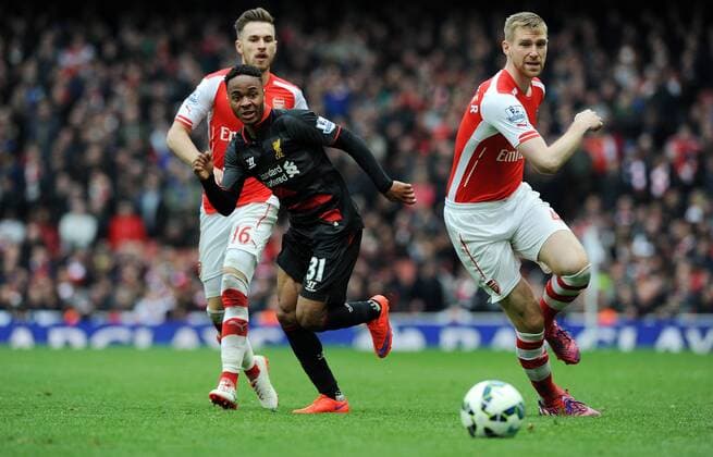 Raheem Sterling of Liverpool is challenged by Per Mertesacker of Arsenal - Barclays Premier League - Arsenal vs Liverpool - Emirates Stadium - London - England - 4th April 2015 - Pic Robin Parker Sportimage EDITORIAL USE ONLY. No use with unauthorised audio, video, data, fixture lists, club league logos or live services. Online in-match use limited to 120 images, no video emulation. No use in betting, games or single club league player publications. TM3_8404.JPG