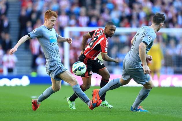 Jermaine Defoe of Sunderland plays the ball between Jack Colback and Mike Williamson of Newcastle United - Sunderland vs. Newcastle United - Barclay s Premier League - Stadium of Light - Sunderland - 05 04 2015 Pic Philip Oldham Sportimage EDITORIAL USE ONLY. No use with unauthorised audio, video, data, fixture lists, club league logos or live services. Online in-match use limited to 120 images, no video emulation. No use in betting, games or single club league player publications.