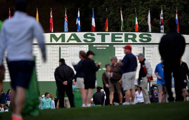 Patrons are seen silhouetted against the main scoreboard during a practice round prior to the 2015 Masters Tournament at Augusta, National in Augusta, Georgia on April 6, 2015.  AUG20150406303 KEVINxDIETSCH