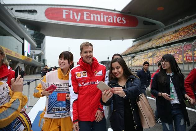 German F1 driver Sebastian Vettel of Ferrari, center, poses with fans for selfies at the Shanghai International Circuit before the 2015 Formula 1 Chinese Grand Prix in Shanghai, China, 9 April 2015. F1 drivers wow fans with signatures and selfies in Shanghai  20150409_64111