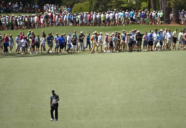Patrons cross as Tiger Woods stands on the 7th hole fairway in the third round of the 2015 Masters Tournament at Augusta National Golf Club in Augusta, Georgia on April 11, 2015.  AUG20150411116 KEVINxDIETSCH