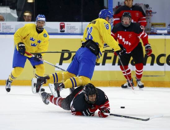 23.94.2015 Zug. Schweiz Eishockey U 18 Weltmeisterschaft , Kanada - Schweden Bossard Arena. Bild zeigt Joel Eriksson (SWE) gegen Glenn Gawdin (CAN) am Boden Aktion Zweikampf Foto 