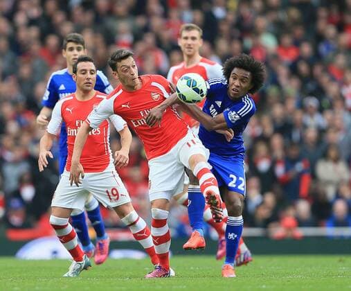 Arsenal s Mesut Ozil tussles with Chelsea s Willian Barclays Premier League - Arsenal vs Chelsea - Emirates Stadium - England - 26th April 2015 - Picture David Klein Sportimage EDITORIAL USE ONLY. No use with unauthorised audio, video, data, fixture lists, club league logos or live services. Online in-match use limited to 120 images, no video emulation. No use in betting, games or single club league player publications.