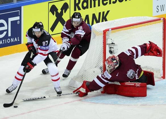 Sidney Crosby of Canada, left, controls a puck past Latvia s Rodrigo Abols, center, and Latvia s goalkeeper Ervins Mustukovs, right, during the Ice hockey Eishockey World Championship WM Weltmeisterschaft Group A match Canada vs Latvia in Prague, Czech Republic, May 1, 2015. (CTKxPhoto RomanxVondrous) CTKPhotoP201505010540401  vnd
