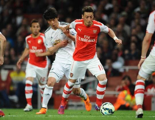 Aktuell Fußball, England, Premier League, FC Arsenal - Swansea City Football - 2014 2015 Premier League - Arsenal vs. Swansea City Mesut Ozil of Arsenal and Ki Sung Yueng of Swansea at The Emirates. COLORSPORT ANDREW COWIE 
