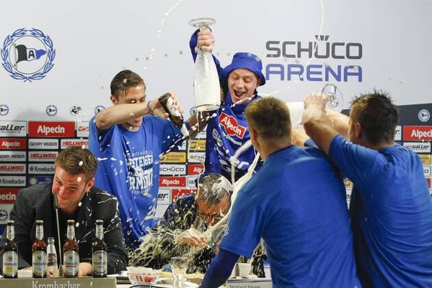 Norbert Meier (DSC Arminia Bielefeld) bekommt waehrend er PK eine Bierdusche von Tom Schuetz (DSC Arminia Bielefeld 6), Julian Boerner (DSC Arminia Bielefeld 13) und Christian Mueller (DSC Arminia Bielefeld 37) Arminia Bielefeld vs SSV Jahn Regensburg, Fussball, 3. Liga, 16.05.2015, Copyright: Schueler Eibner-Pressefoto EP_JSE