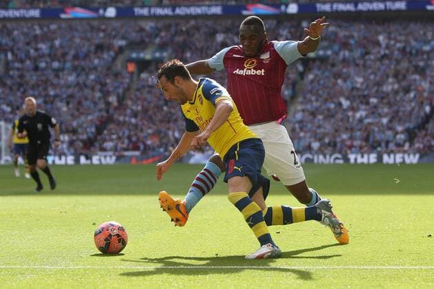 Christian Benteke of Aston Villa challenges Arsenal s Santi Cazorla - Arsenal vs. Aston Villa - FA Cup Final - Wembley Stadium - London - 30 05 2015 Pic Philip Oldham Sportimage EDITORIAL USE ONLY. No use with unauthorised audio, video, data, fixture lists, club league logos or live services. Online in-match use limited to 120 images, no video emulation. No use in betting, games or single club league player publications.